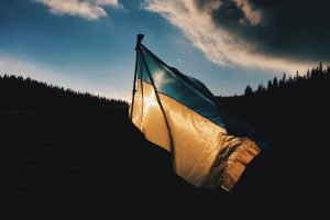 Ukrainian flag, flying in a dark landscape