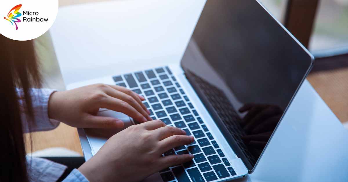 A close-up of hands on a laptop.